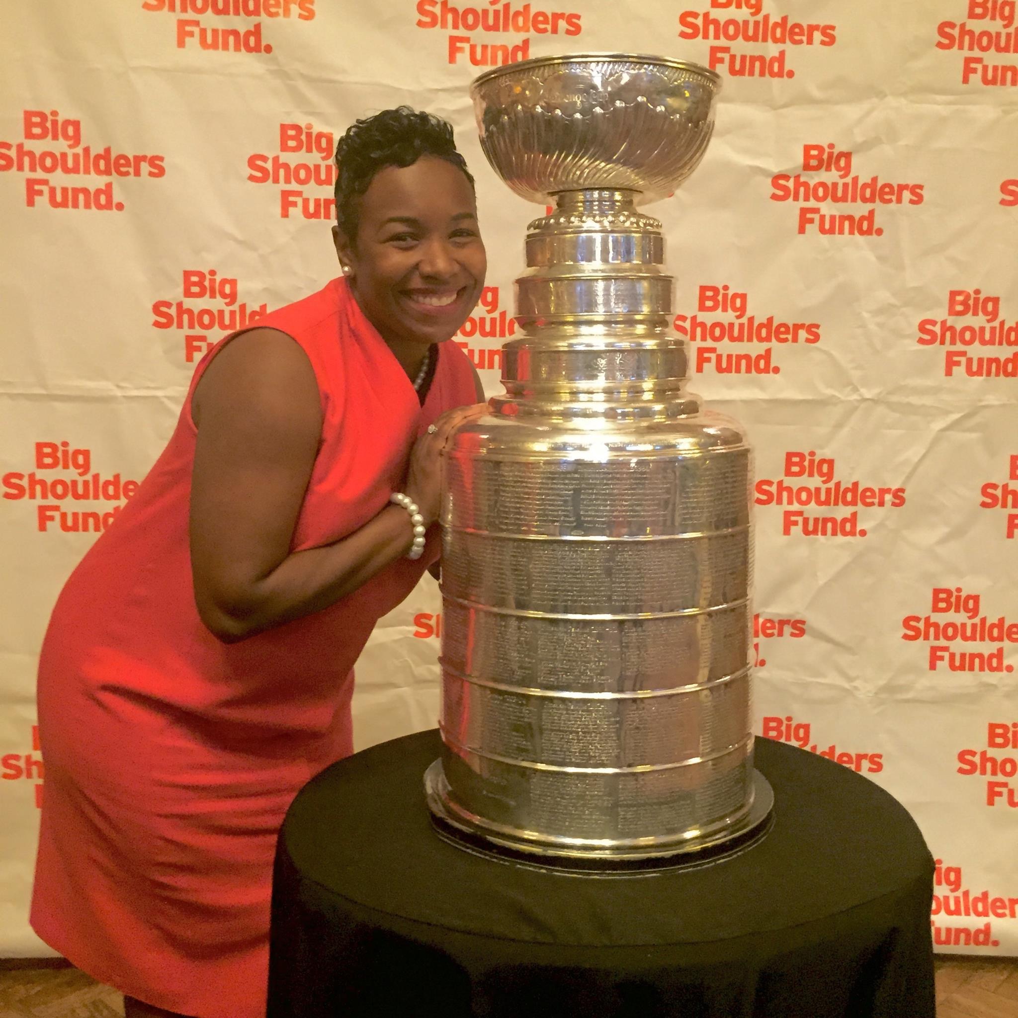 Smiling beside the Stanley Cup in front of a Big Shoulders Fund backdrop